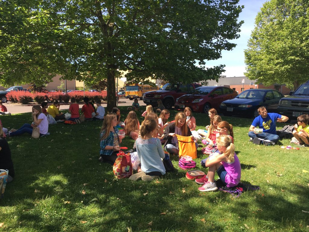 Kids eating lunch under the trees